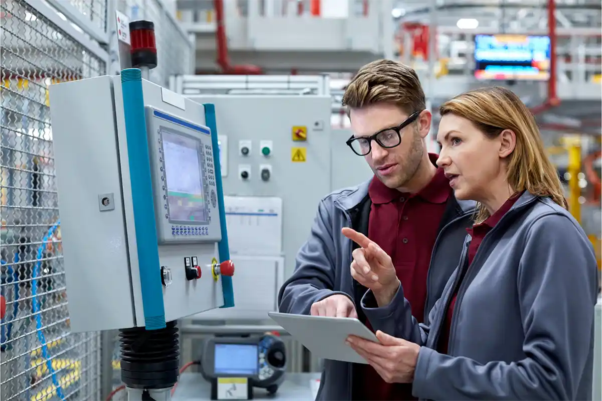 Two people looking at machinery with a clipboard